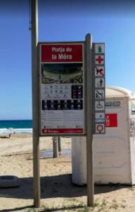 a sign on the beach next to a trash can at Cala Azul 304-306 Tamarit in Tamarit