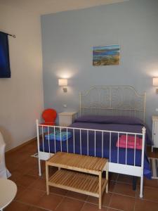 a room with a bed with a bench in it at B&B Sa Tuerra in Teulada +70 photos