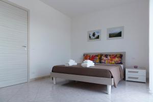 a bedroom with a bed and a white wall at Terrazza Sui Colli in Monopoli