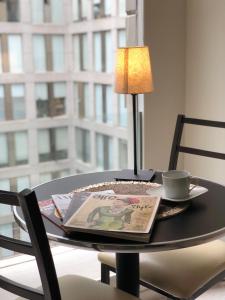 a table with a newspaper and a cup and a lamp at Boutique Apartment Puerta Alameda-801 in Mexico City