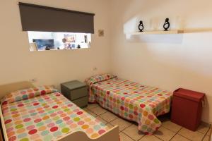 カレタ・デ・ファマラにあるCasa Maralba Famaraのベッド2台と窓が備わる小さな客室です。
