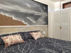 a bedroom with a bed with two pillows and a painting at Ocean View Apartment in Palm-mar