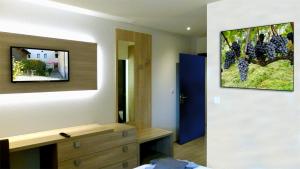 a bedroom with a painting of grapes on the wall at Le charme du prieuré in Etoy