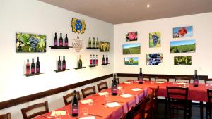 una sala da pranzo con tavolo e bottiglie di vino appese al muro di Le charme du prieuré a Etoy