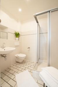a bathroom with a shower and a toilet and a sink at Hotel Forsthaus Sellin in Ostseebad Sellin +79 photos