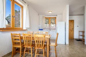 a kitchen with a table and chairs and a refrigerator at Dębki Domki Bliźniaki Z OGRZEWANIEM in Dębki