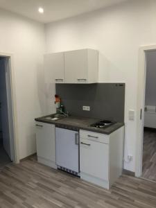 a kitchen with white cabinets and a counter top at Hotel zum Adler in Bad Homburg vor der Höhe