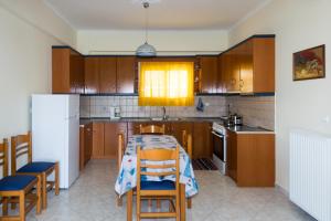 uma cozinha com uma mesa e cadeiras e um frigorífico em Vithos Apartment em Kalamata