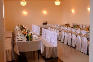 a dining room with white tables and white chairs at Odzun Hotel in Alaverdi