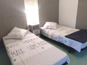 two beds in a room with writing on them at la longere de Lor'Phée in Chantepie