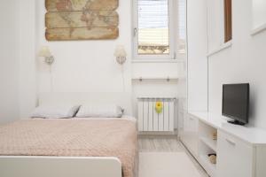 1 dormitorio pequeño con 1 cama y TV en New Charming Studio, en Bucarest