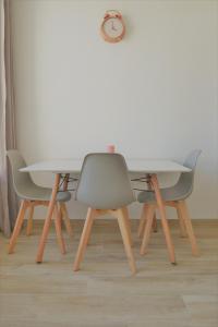 uma mesa e duas cadeiras e um relógio na parede em Studio Lovely Sea em Le Barcarès