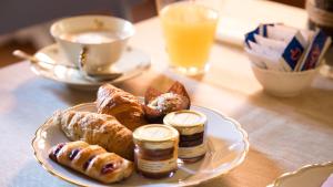 a plate of food with pastries on a table at Rinascimento Bed & Breakfast in Pisa +37 photos