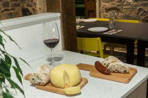 a glass of wine and a plate of cheese and bread at Albergue O Candil in Melide +15 photos
