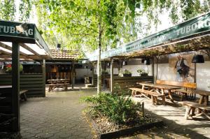 un grupo de mesas de picnic fuera de un restaurante en Hotel Vildbjerg, en Vildbjerg