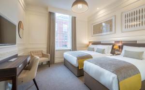 um quarto de hotel com duas camas e uma secretária em Hotel 7 em Dublin