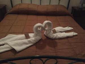 Dos cisnes hechos de toallas en una cama en Sciacca Bed and Breakfast Natoli, en Sciacca