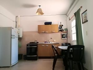 cocina con nevera blanca y mesa en Departamento Alvarado en Salta