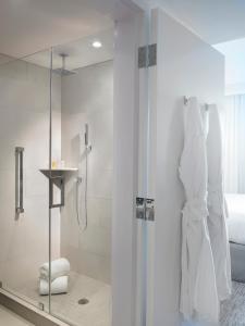 a bathroom with a shower with a glass door at Grand Beach Hotel Bay Harbor in Miami Beach