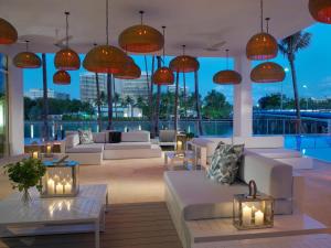 a hotel lobby with white couches and tables and lights at Grand Beach Hotel Bay Harbor in Miami Beach