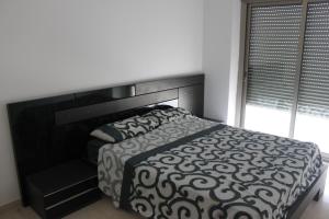 ベニカルロにあるDuplex Apartamentoのベッドルーム1室(大型ベッド1台、黒いヘッドボード付)