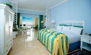 a bedroom with a large bed and a dining room at Pueblo Bonito Emerald Bay Resort & Spa - All Inclusive in Mazatlán +26 photos