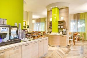 eine große Küche mit grünen Wänden und einer Cafeteria in der Unterkunft Hotel Fabrizio in Rimini