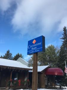 una señal azul en un poste frente a un lodge en Centerstone Resort Lake-Aire en Tomahawk
