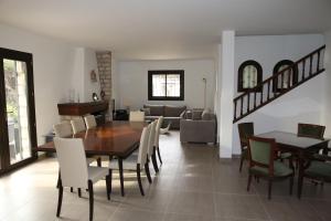 uma sala de jantar e sala de estar com mesa e cadeiras em Superbe villa de charme avec piscine chauffée em Roquefort Les Pins