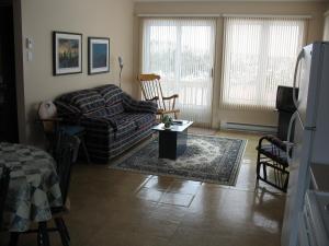 a living room with a couch and a table at Les Chalets au Bord de la Mer in Les Escoumins