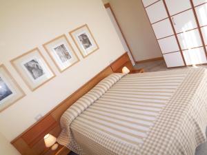 a bed in a bedroom with pictures on the wall at Euroresidence Apartments in Lido di Jesolo