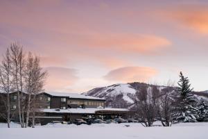 パークシティにあるHotel Thaynes, Park City, a Tribute Portfolio Hotelの山を背景にした雪の中の建物