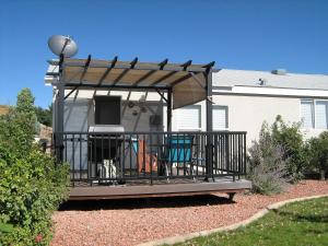 a gazebo with two chairs on a deck at Kokopelli Kottage in Kanab