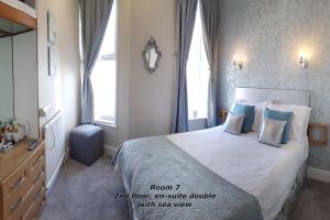スカーバラにあるThe Paragon - Guest Accommodationのベッドルーム1室(ベッド1台、ドレッサー、窓付)