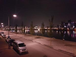 a parking lot with a van parked next to a river at night at Sewdien’s Apartment Maashaven in Rotterdam