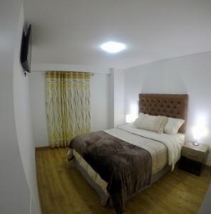 una camera con un grande letto e una televisione di Casona Apartament ad Arequipa