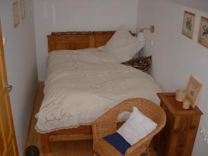 a small bedroom with a large bed with white sheets at Nyerges Lovasudvar in Cserépfalu