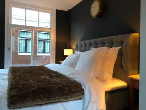 a bedroom with a large bed with a clock on the wall at The Lastage Inn - Bed & Breakfast in Amsterdam