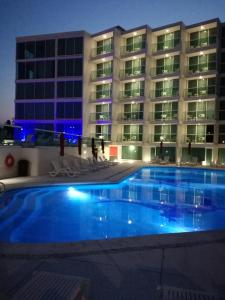 a swimming pool in front of a building at night at We Hotel Acapulco in Acapulco