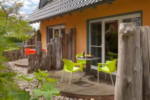 een patio met een tafel en stoelen voor een huis bij Ferienhaus Lütten Kulli - 2 in Zingst