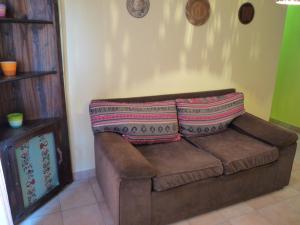 un sofá con 2 almohadas en una habitación en Killasumaq en Salta