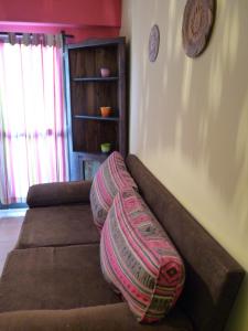un sofá con almohadas en la sala de estar. en Killasumaq en Salta