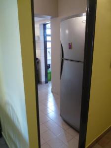 a kitchen with a white refrigerator in a hallway at Killasumaq in Salta
