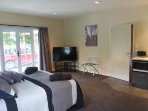 um quarto de hotel com duas camas e uma televisão de ecrã plano em GMH Home Stay em Blenheim