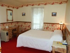 een slaapkamer met een bed, een bureau en een raam bij Bridgeport Inn in Bridgeport