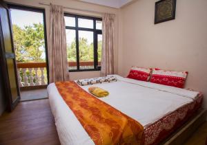 ein Bett in einem Zimmer mit einem großen Fenster in der Unterkunft Langtang View Nagarkot Bed and Breakfast in Nagarkot