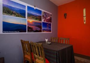 ein Esszimmer mit einem Tisch mit Stühlen und Bildern an der Wand in der Unterkunft Langtang View Nagarkot Bed and Breakfast in Nagarkot