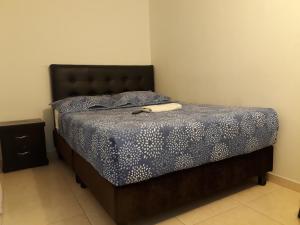 Un dormitorio con una cama con un edredón azul. en Aparta Hotel Victoria In, en Bogotá