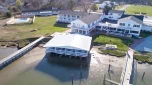 an aerial view of a large house on the water at Wylder Hotel - Tilghman Island in Tilghman Island