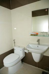 La salle de bains est pourvue de toilettes blanches et d'un lavabo. dans l'établissement Hoang Dang Hotel, à Tuy Phong